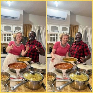 blond woman laughing, black guy with glasses smiling in the kitchen with a few dishes in pots in front of them